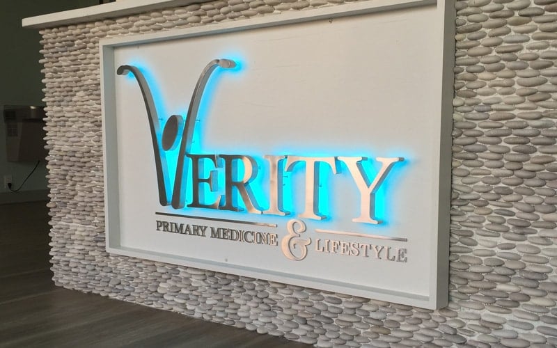 backlit halo letters with RGB blue LEDs in brushed stainless steel mounted inside medical lobby