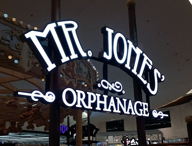 front lit channel letters in white and black mounted on hanging brackets