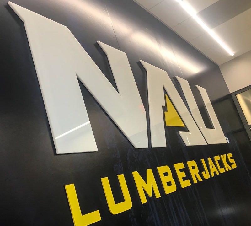 custom acrylic letters and logo in white and yellow glossy for inside university athletics facility