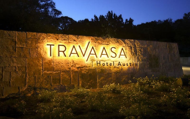 backlit letters and flat cut aluminum letters painted black with warm white leds mounted outside for hotel monument entry