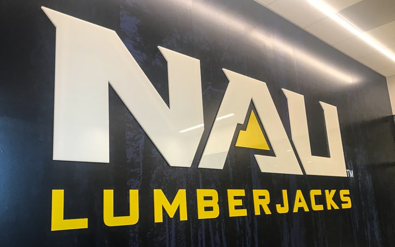 custom acrylic letters and logo in white and yellow glossy for inside university athletics facility