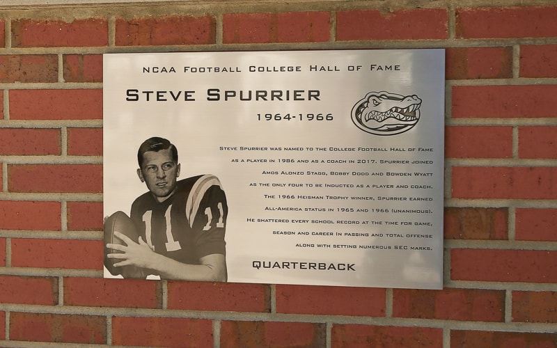brushed etched stainless steel plaque with etched image portrait mounted outside on brick university stadium
