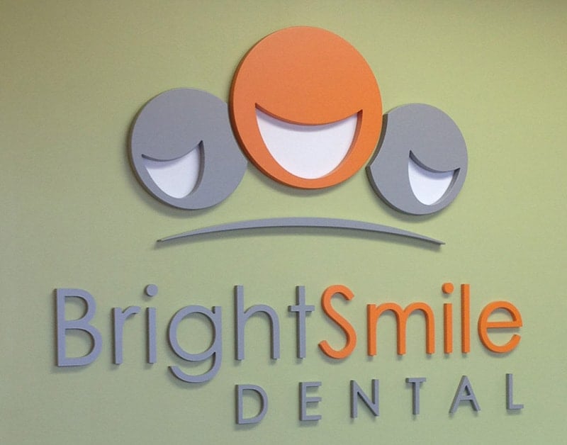 interior foam sign with custom logo and lettering orange and grey on tan wall